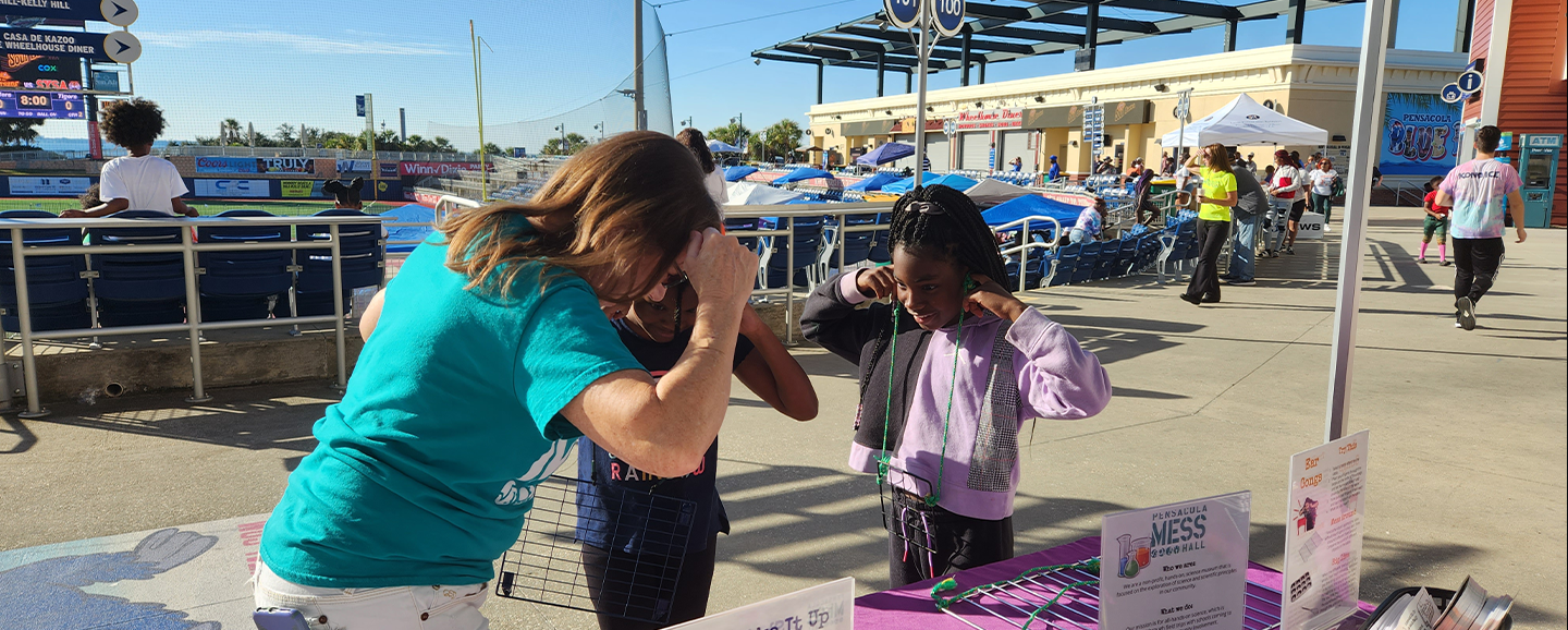 Adult and Children experiencing Ear Gongs Sound Book from MESS Hall Pensacola